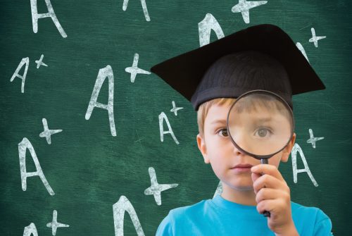 Digital composition of boy in graduation cap holding magnifying glass against A positive sign in background
